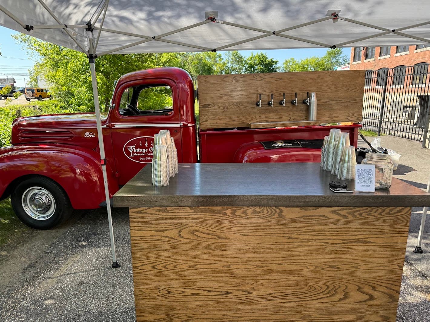 Front angle view of vintage truck bar setup at daytime event with tent