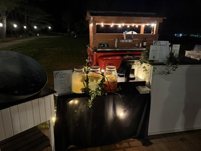 1968 Chevy tap trailer nighttime setup with string lights and infused water station